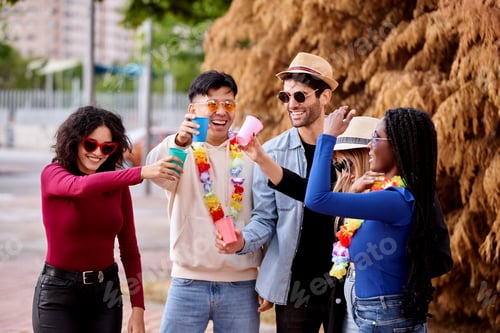 Preview: Group of friends having fun while partying together outdoors.