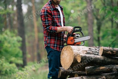 Preview: cropped view of lumberjack cutting round timbers with chainsaw in forest