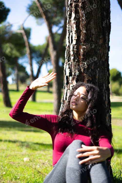 Preview: Latin woman protecting her eyes from sunlight in a park