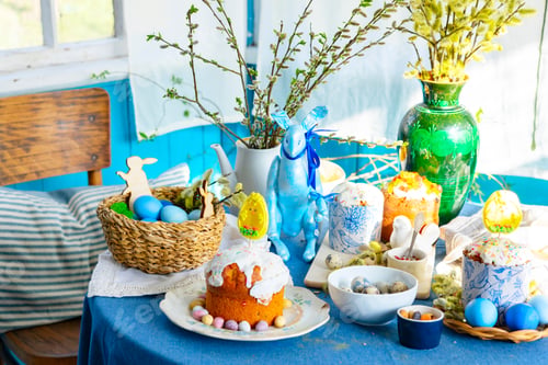 Preview: table set for Easter on veranda on sunny spring day decorated with flowers and Easter decor, eggs, c