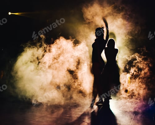 Preview: silhouette of a woman dancing between lights and smoke