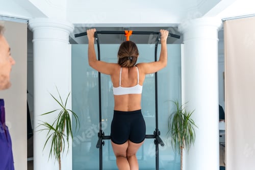 Preview: Woman doing pull up for sports physiotherapy recovery