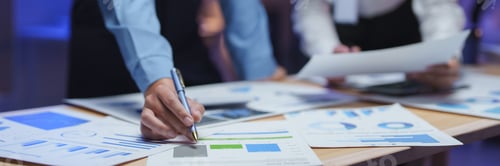 Preview: Business team analyzing financial documents with charts and graphs at night