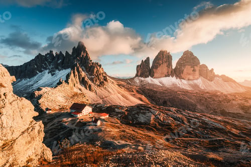 Preview: Alpine landscape of sunset over Tre Cime mountain peak and mountain hut in Dolomites