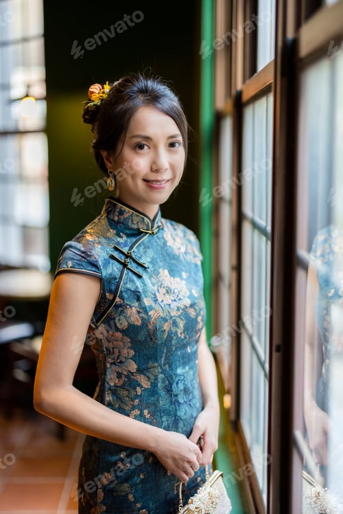 Preview: Woman wear traditional cheongsam in the restaurant