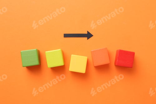 Preview: Maximum. Colorful cubes and arrow on orange background, flat lay