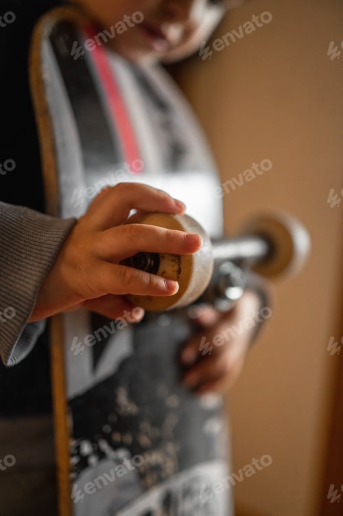 Preview: Details. A little boy is holding a skateboard