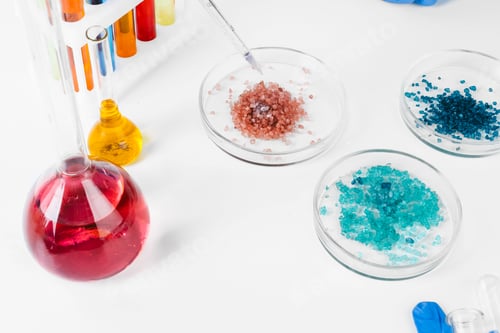 Preview: Colored liquids inside lab glassware on white table in laboratory