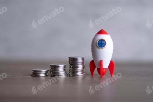 Preview: Closeup image of rocket spaceship and coins.