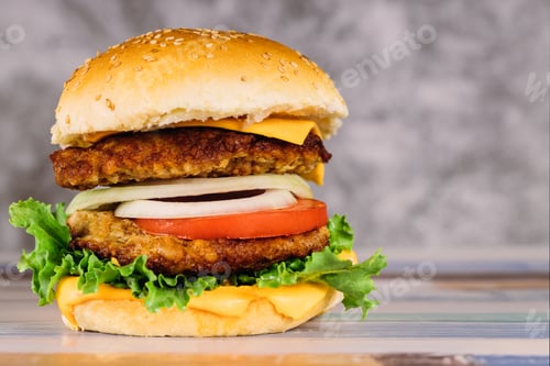 Preview: Double juicy burger with vegetables on white table.