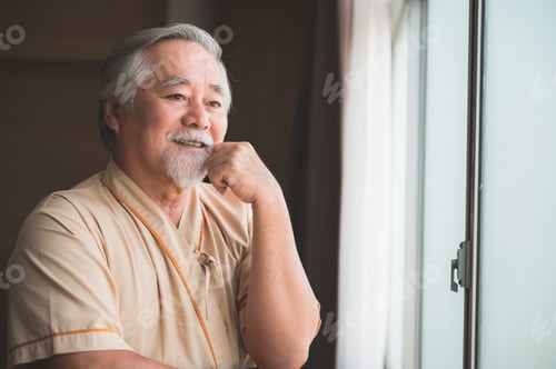 Preview: an elderly patient look at city view through hospital's window, asian old man smiling