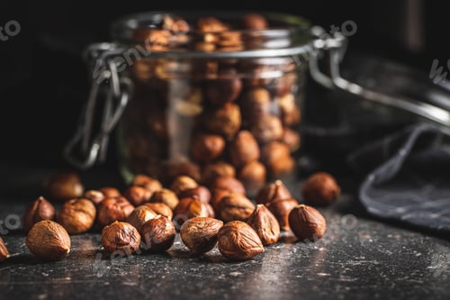 Preview: Peeled hazelnuts on old kitchen table.
