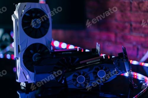 Preview: Graphics cards of different sizes and configurations on black table under neon light. Part of