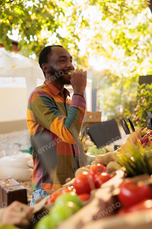 Preview: Smiling male person tasting apple before buying bio produce