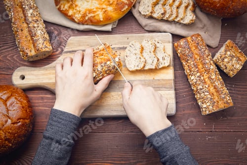 Preview: Woman cutting a baguette and other breads.