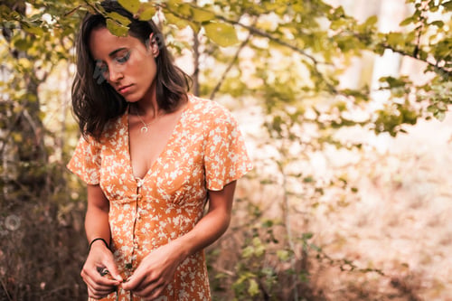 Preview: Outdoor portrait of a beautiful brunette woman wearing a dress in the forest
