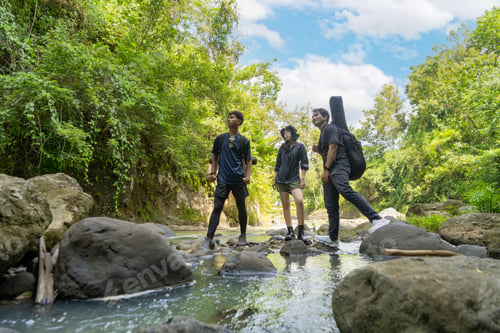 Preview: group of young asian standing on the rock while hiking and trekking in tropical nature