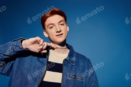 Preview: Handsome young man expresses deep emotions against a vibrant blue background