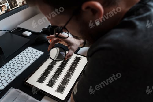 Preview: Photographer examining negatives with magnifying glass