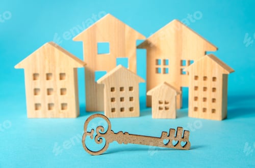 Preview: Key on the background of miniature wooden houses. Real estate buying and selling concept.