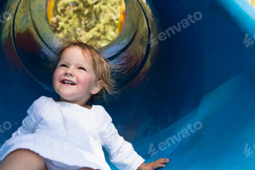 Preview: Female toddler sliding down tube slide, Sagres, Algarve, Portugal