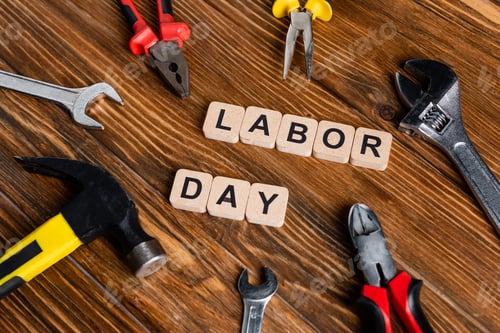 Preview: different tools and cubes with labor day lettering on wooden surface