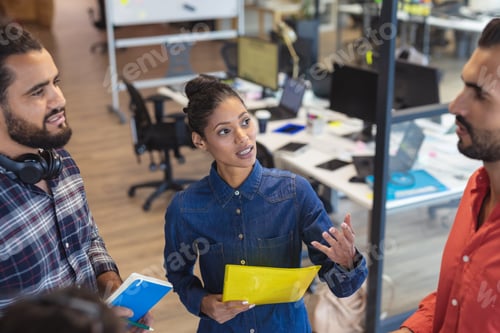 Preview: Diverse group of creative colleagues talking at casual meeting