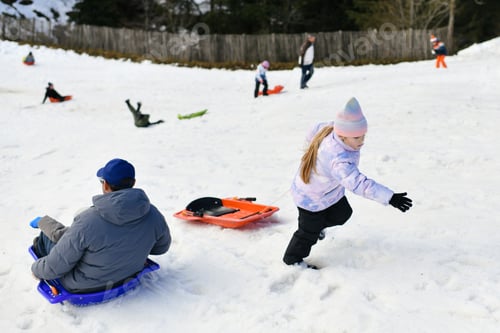 Preview: A father with child sledding in the snow