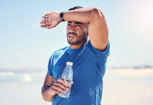Preview: Shot of a man holding a bottle water while looking exhausted during his run