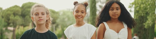 Preview: Smiling three girls friends pre-teenage cross their arms in dance move in the park