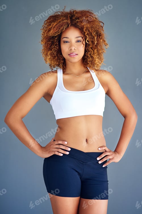 Preview: Cropped shot of a sporty young woman posing against a grey background
