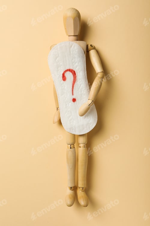 Preview: Menstrual cycle concept, wooden figurine of a man holding a pad