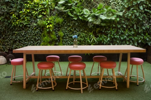 Preview: table and chairs in garden with Green leaves with vegetation on wall background