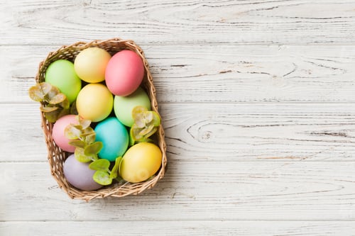 Preview: Multi colors Easter eggs in the woven basket on colored background