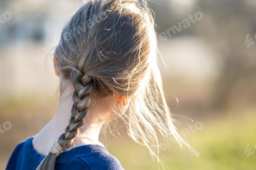 Preview: Young Girl with Braided Hair in Sunlight