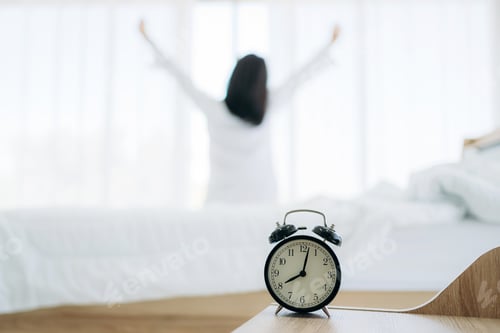 Preview: Close up of alarm clock on bedside table. Young Woman Waking Up with Happiness.