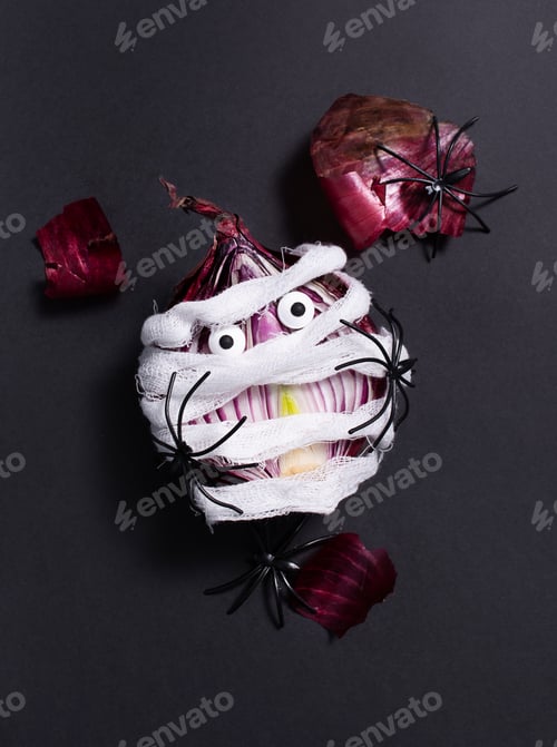 Preview: Halloween food.Frightened bulb with eyes wrapped in a bandage on a dark background.