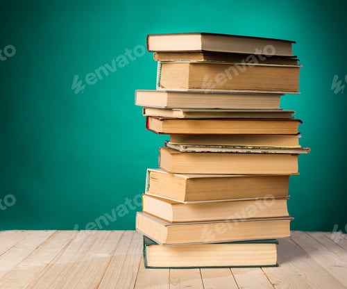 Preview: Stack of old books arranged on wooden surface with green background in a cozy setting