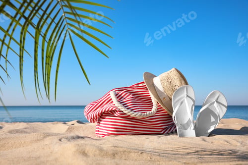 Preview: Set with stylish beach accessories on sand near sea