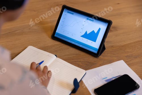Preview: Mid section of caucasian casual businesswoman using tablet in office