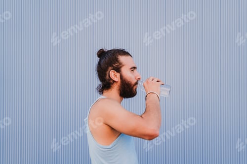 Preview: hispanic man in the city practicing yoga sport. blue background. healthy lifestyle