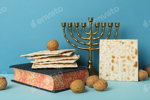 Preview: Matzo, nuts, hanukkiah and Torah on blue background