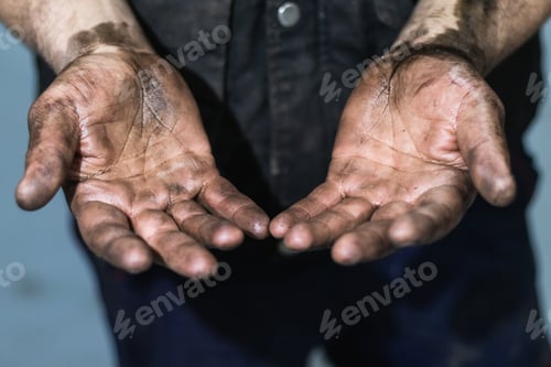 Preview: Mechanic showing dirty hands in car workshop