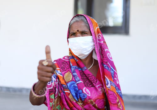 Preview: Vertical shot of an Indian woman with a traditional dress and white mask showing OK