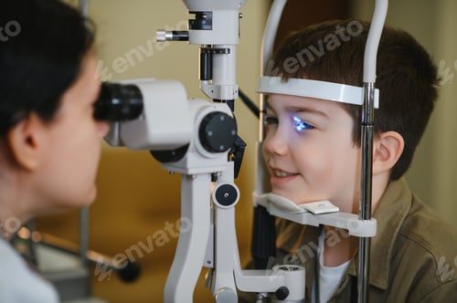 Preview: Ophthalmologist examining child's vision with medical equipment in clinic