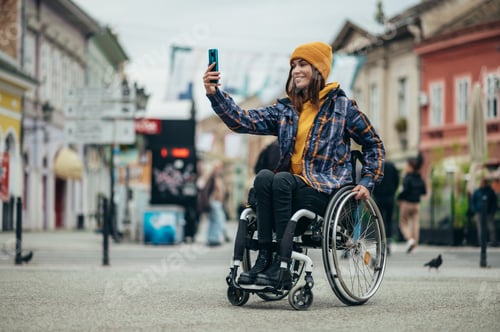 Preview: Woman with disability taking a selfie with her smartphone while out in the city