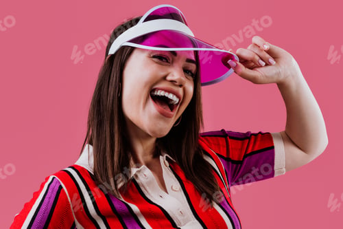 Preview: Woman wearing vibrant striped polo and pink visor