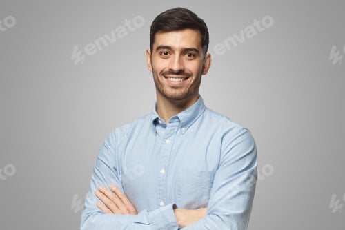 Preview: Modern businessman in blue shirt standing with crossed arms, isolated on gray