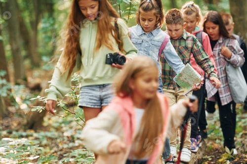Preview: With touristic equipment. Kids in green forest at summer daytime together