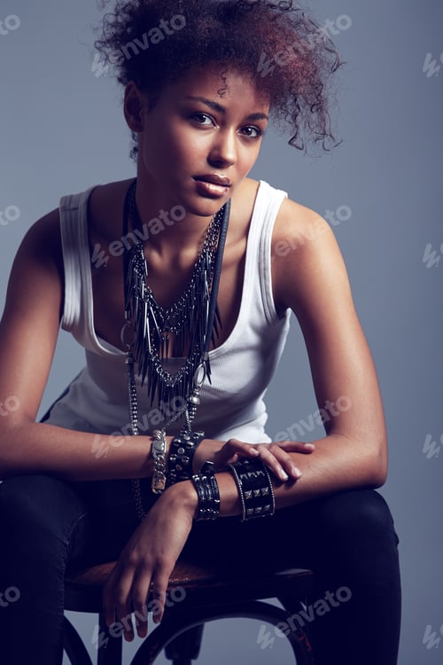 Preview: Rocker chic. A trendy young woman sitting on a chair.